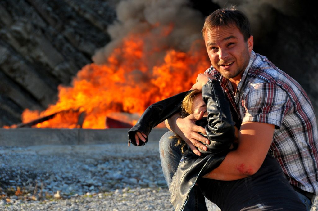 Андрей Чадов на фоне горящей машины